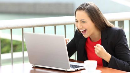 picture of an excited woman working on her laptop
