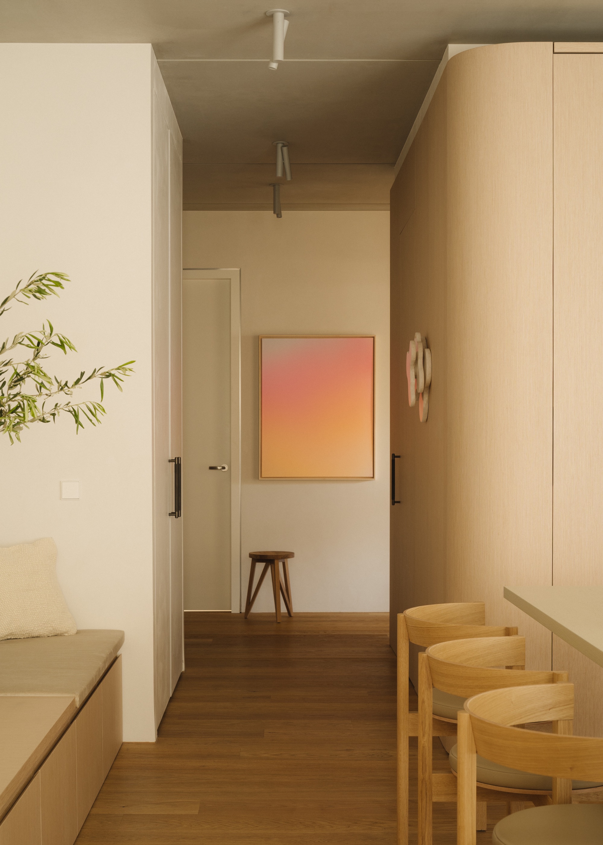 Scandi kitchen and hallway with wall wash lighting and a view of a stool with wall art hanging
