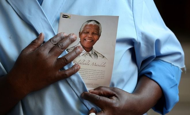 A parishioner holds a pamphlet with the image of Nelson Mandela during church service at Regina Mundi Catholic Church on December 8 in Soweto, South Africa.