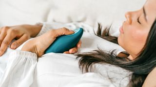 Woman holding a Moonbird breathing coach device