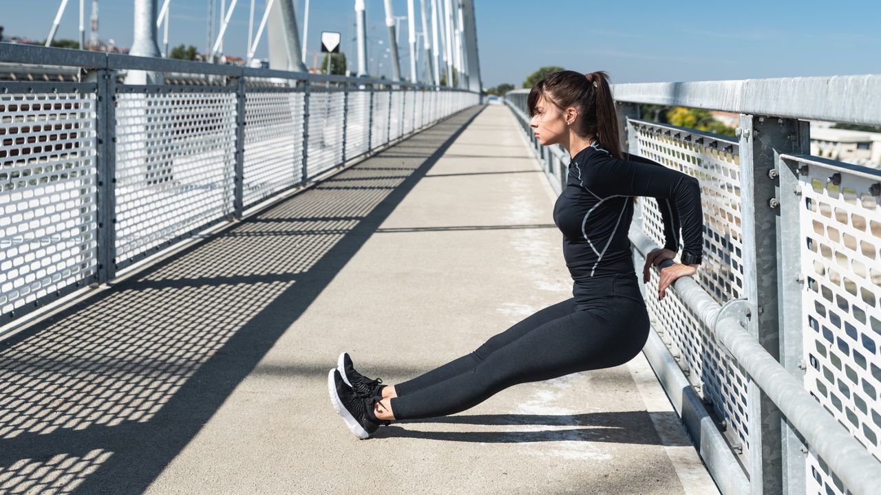 How to do triceps dips: Pictured here, a young sweaty active fitness athletic woman doing dips exercise for triceps and biceps muscle outdoor as workout and training for arm muscles, female sport and recreation concept