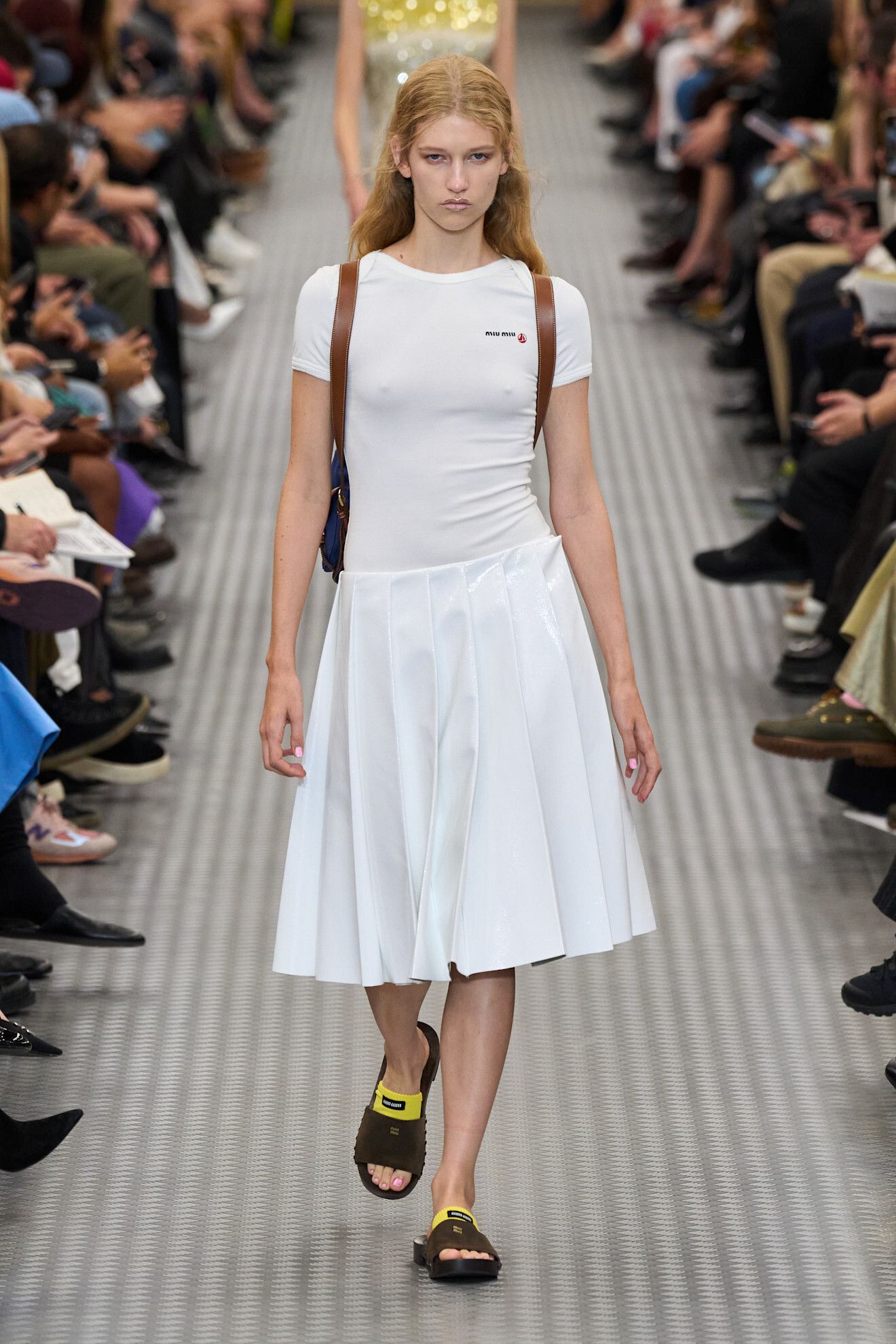 A woman walking down the runway wearing a miu miu outfit