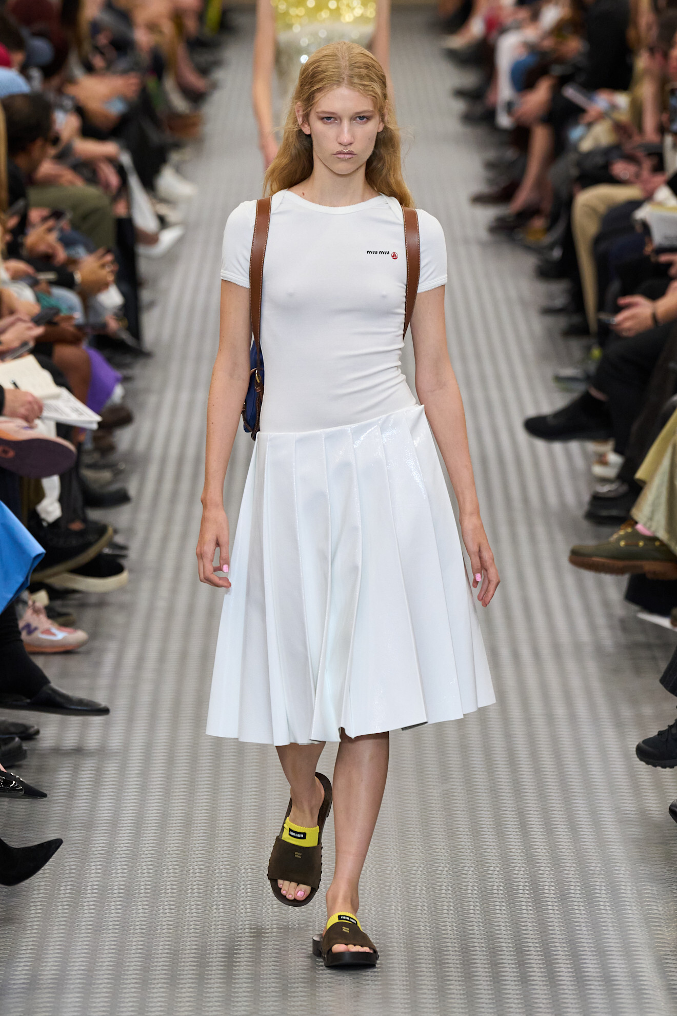 A woman walking down the runway wearing a miu miu outfit