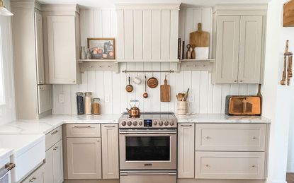 White cooker range in farmhouse kitchen with pots and pans hanging on the wall