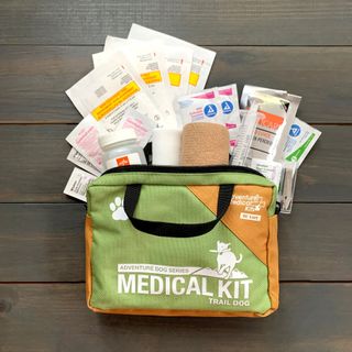 The Trail Dog medical kit opened to show bandages, ointment packets, a syringe and gauze