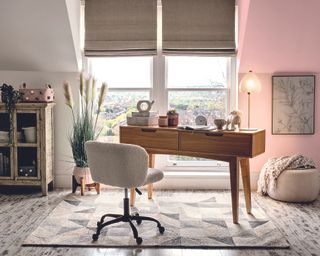 Boucle teddy material desk chair in home office with rug and pink walls
