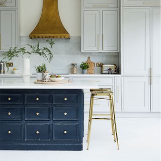 black and white kitchen with white cupboards and gold finishes