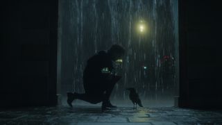 Morpheus kneels down to talk to raven emissary Michael in The Sandman on Netflix