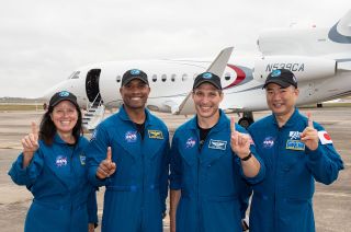 SpaceX Crew-1 astronauts Shannon Walker, Soichi Noguchi, Victor Glover and Michael Hopkins hold up their index fingers as a nod to their mission designation (Crew-1) and their adopted motto, "All for '1,' one for all."