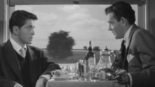 Farley Granger listening to a proposition from Robert Walker in Strangers on a Train