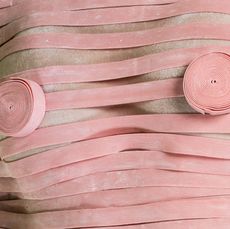 Womans breasts covered in strips of pink gum