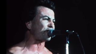 The lead singer of the band Fear, Lee Ving, singing into a microphone