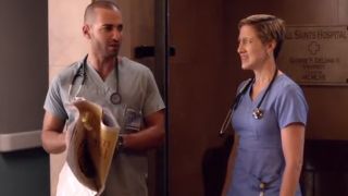 Haaz Sleiman in scrubs talking to Edie Falco, also in scrubs.