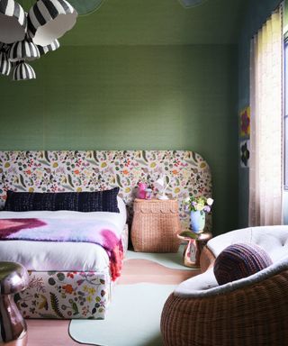 bedroom with green walls, floral oversized headboard, cozy decor