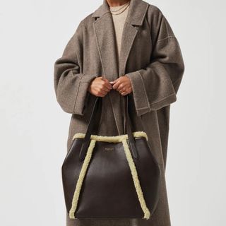 christmas gifts for her woman holding folded shearling lined tote bag