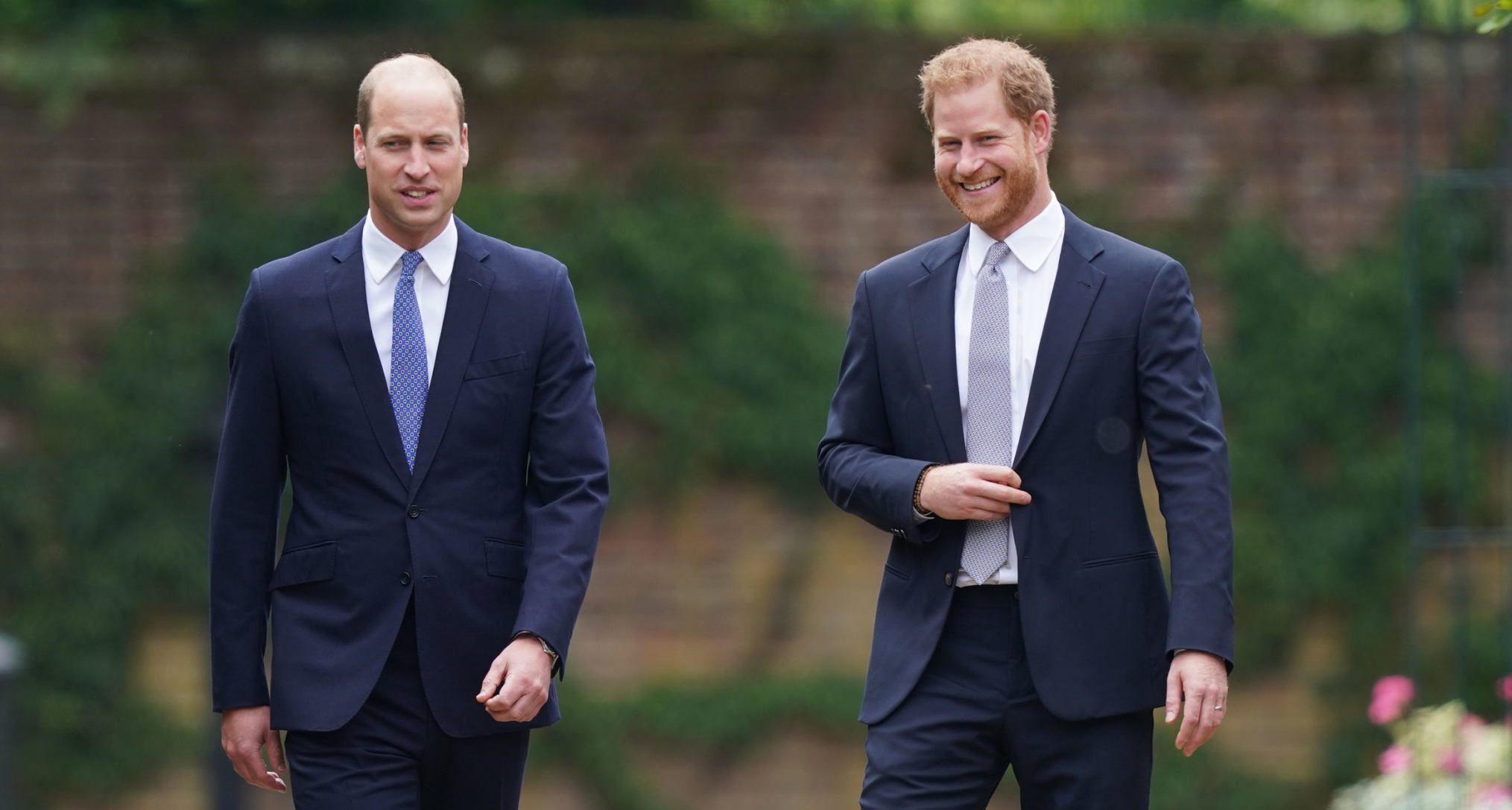 Prince William and Prince Harry walking in blue suits at Kensington Palace