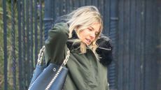 Sienna Miller wearing green winter coat and leather handbag in New York City on January 28, 2020