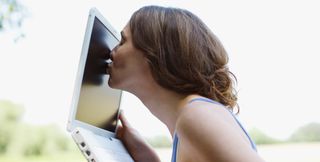 Woman kissing her laptop