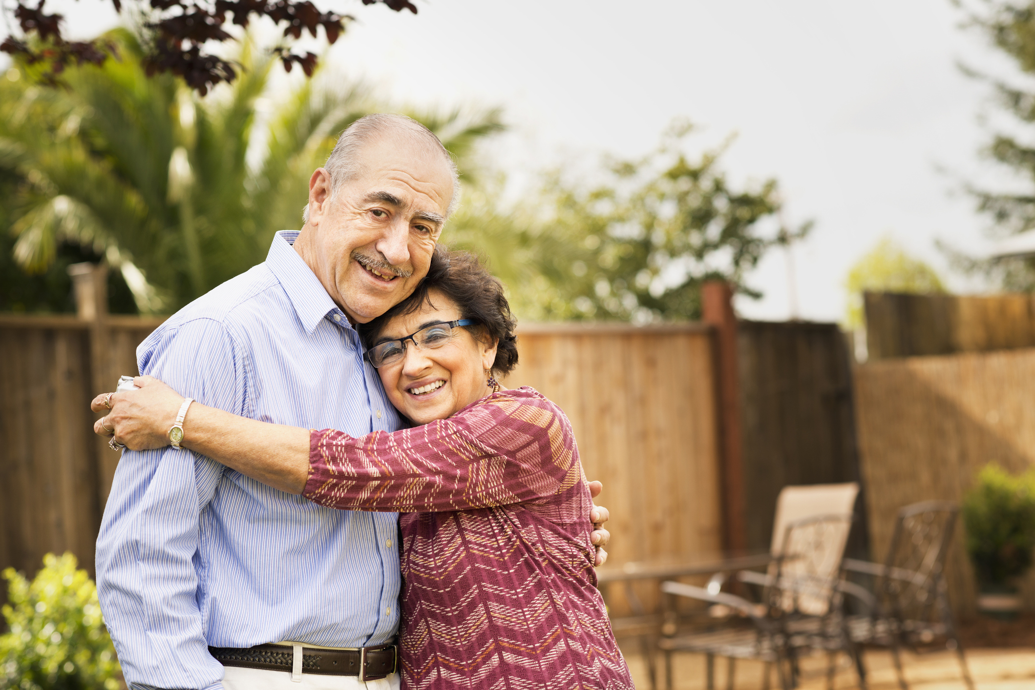 Elderly couple smiling and hugging