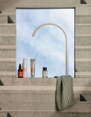 Shower seen through window with toiletries lined up on ledge