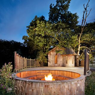 lit fire pit in treehouse decking area