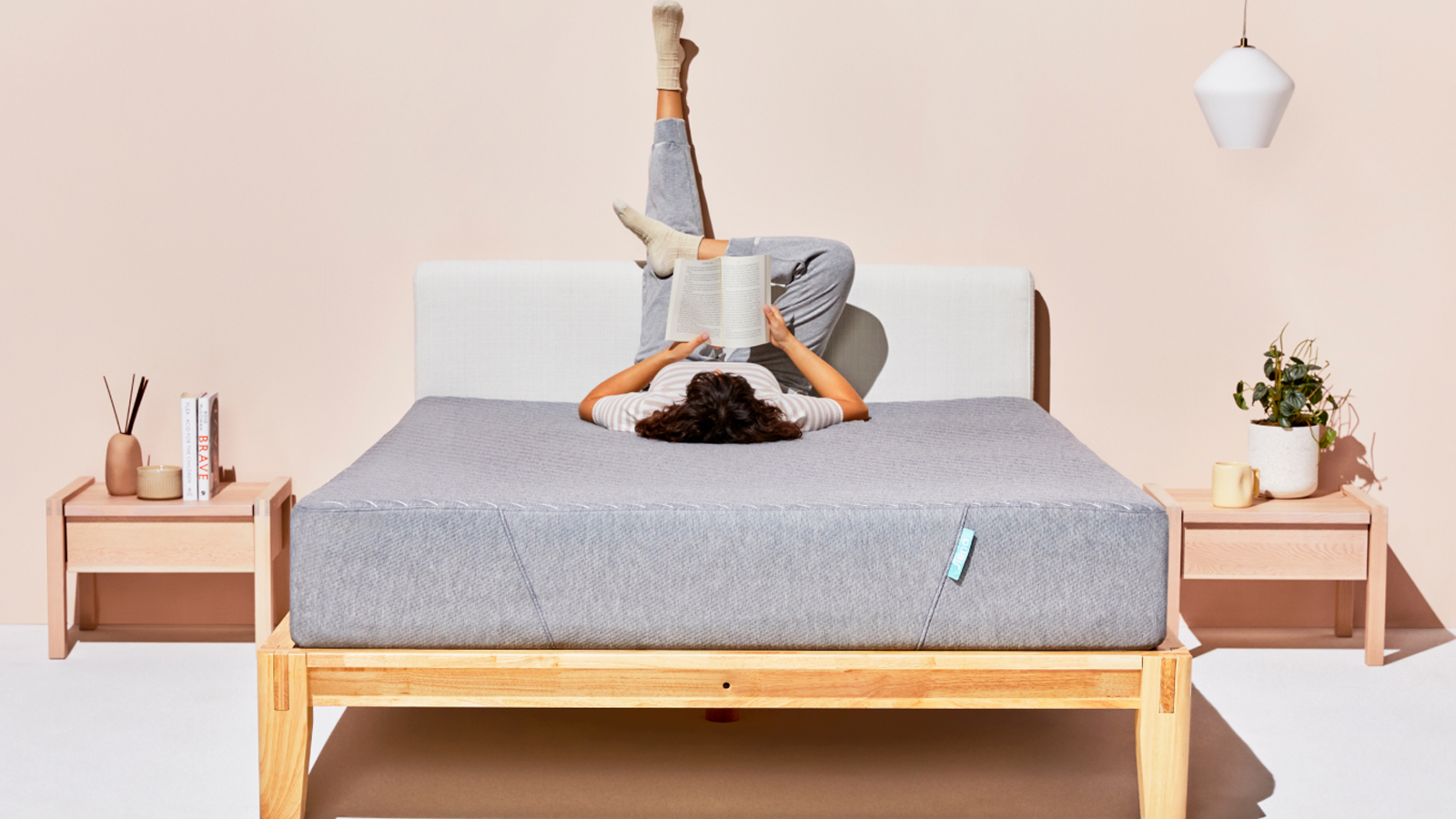 Siena Sleep memory foam mattress, featuring a person lying upside on the bed reading a book