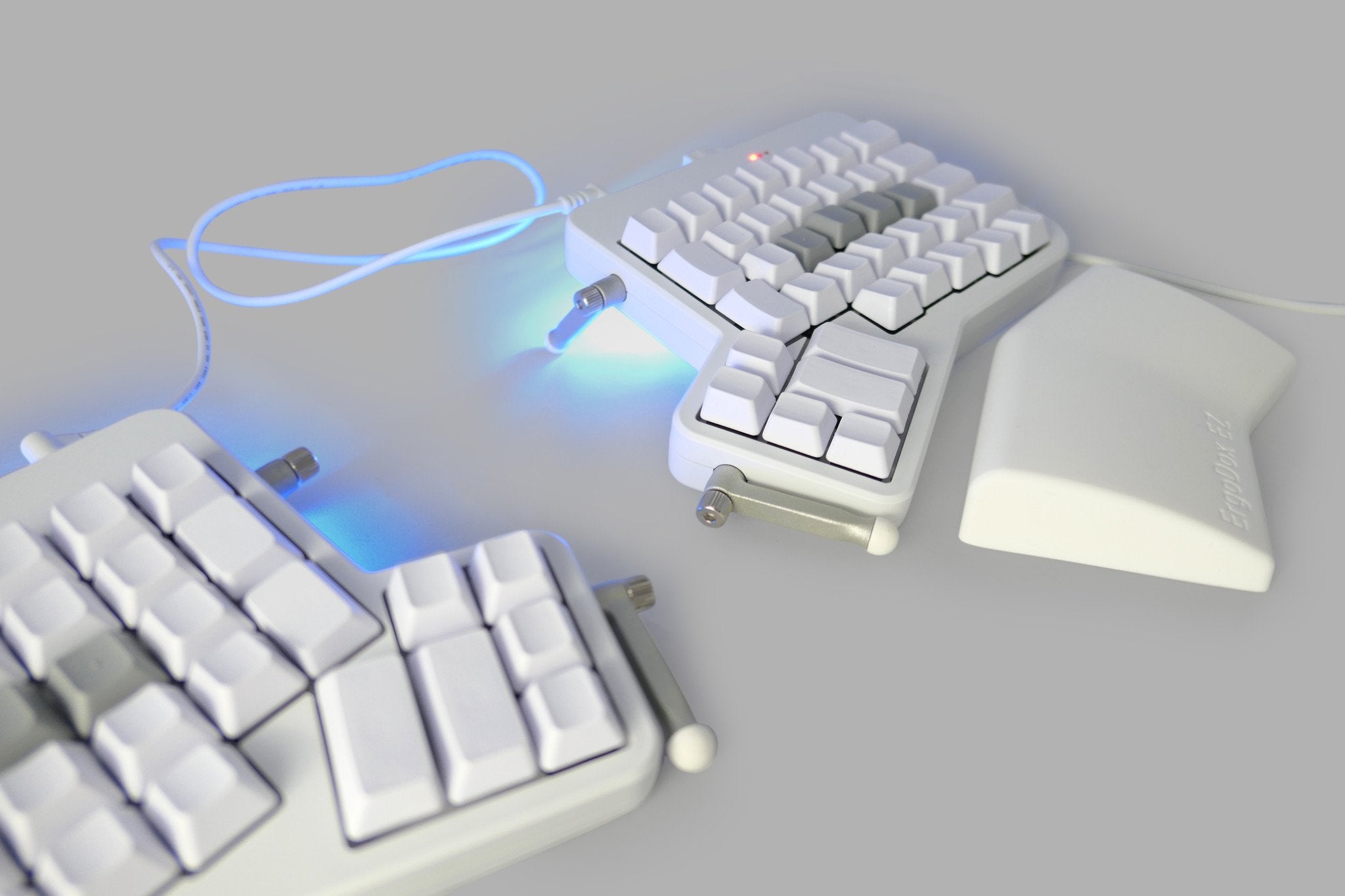 Un ErgoDox EZ, un teclado dividido blanco con teclas en blanco.