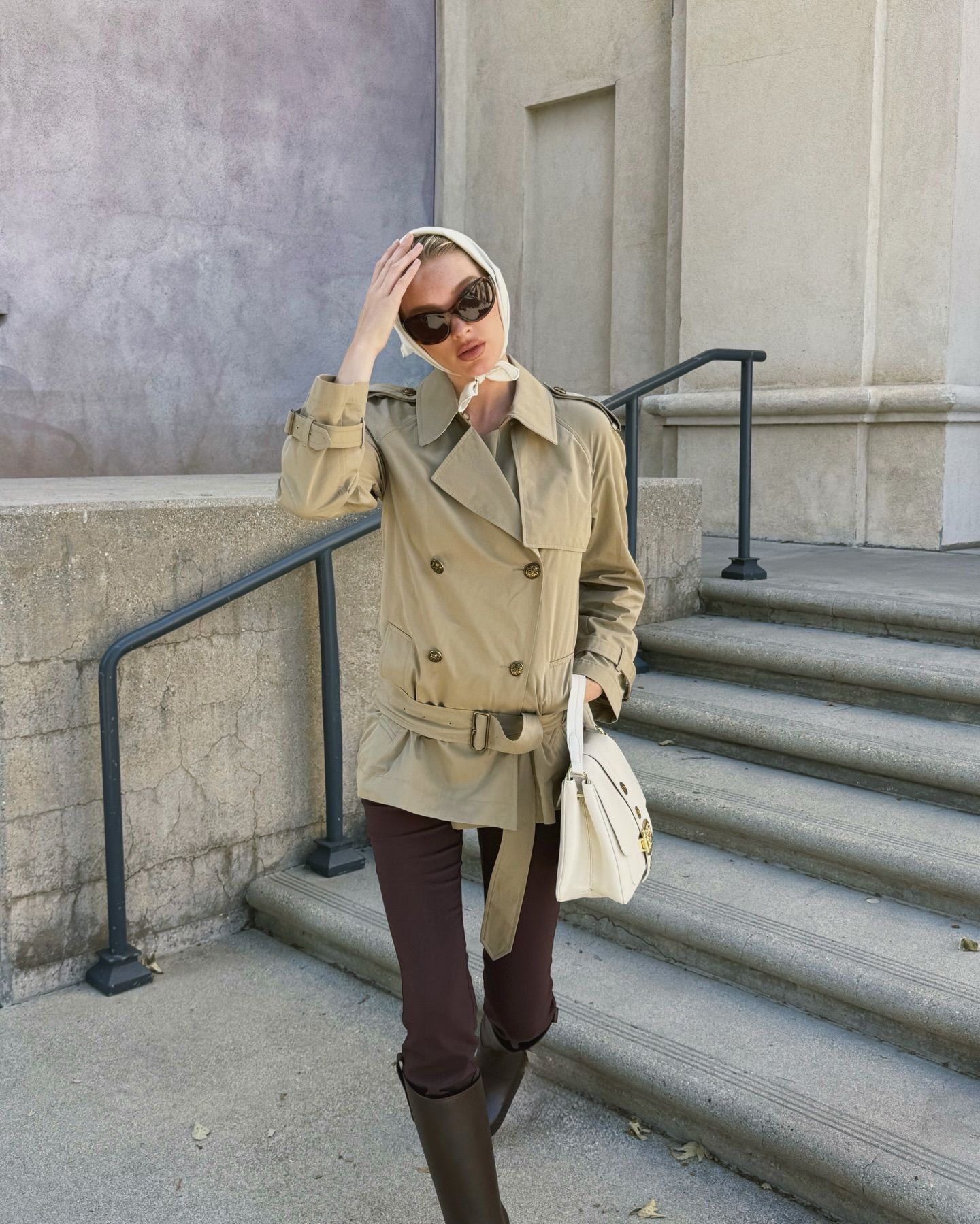 An image of @hoskelsa wearing a Burberry trench coat with brown leggings and riding boots.