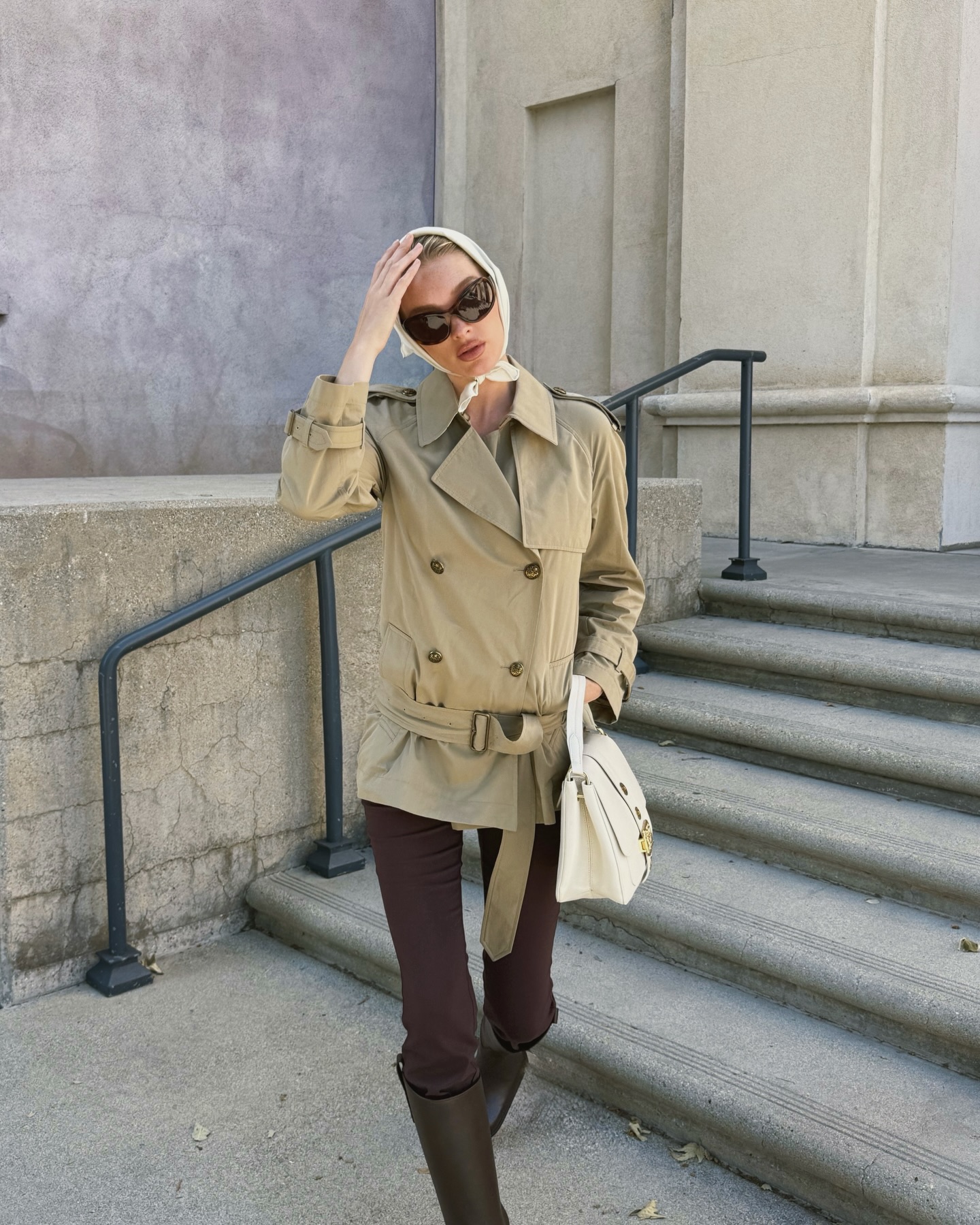 An image of @hoskelsa wearing a Burberry trench coat with brown leggings and riding boots.