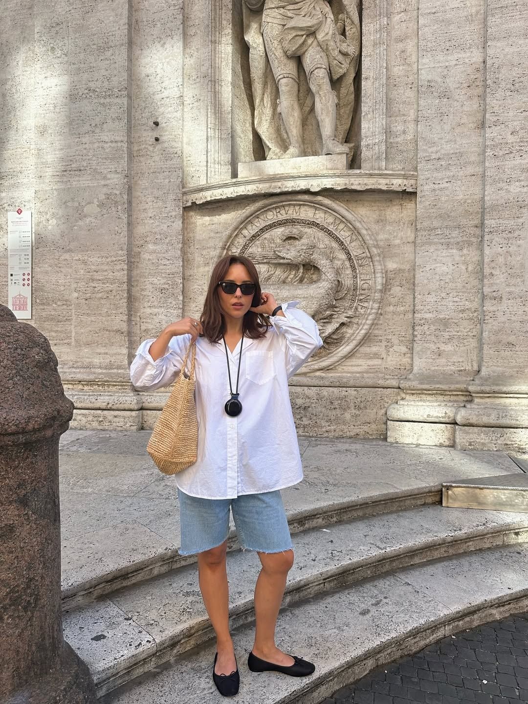 Influencer wearing denim shorts with a white button-down shirt and ballet flats
