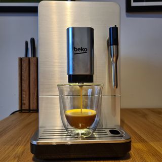 Beko CEG5311X Bean to Cup coffee machine pouring into glass mug