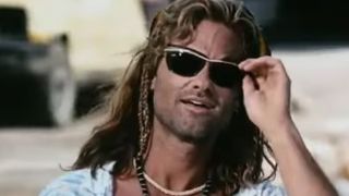 Kurt Russell with long hair, wearing sunglasses in Captain Ron