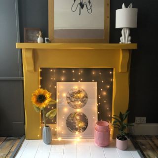 yellow fireplace and black walls and fairy lights