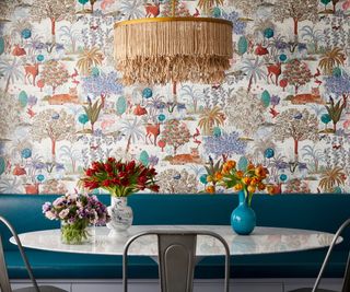 Dining room with floral wallpaper and large pendant light