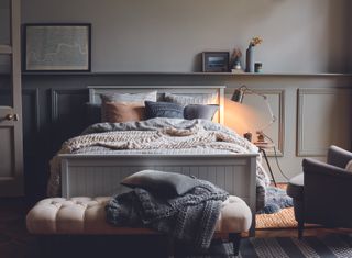 Bedroom with wall panels and a white bed