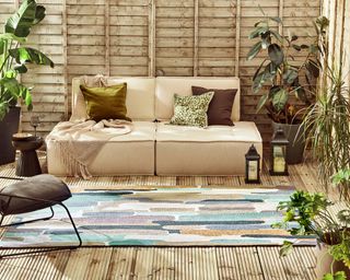 patterned outdoor rug with sofa, planters and lanterns