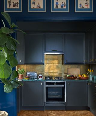 Dark blue kitchen with gold backsplash