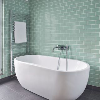 bathroom with tiled walls and white bathtub