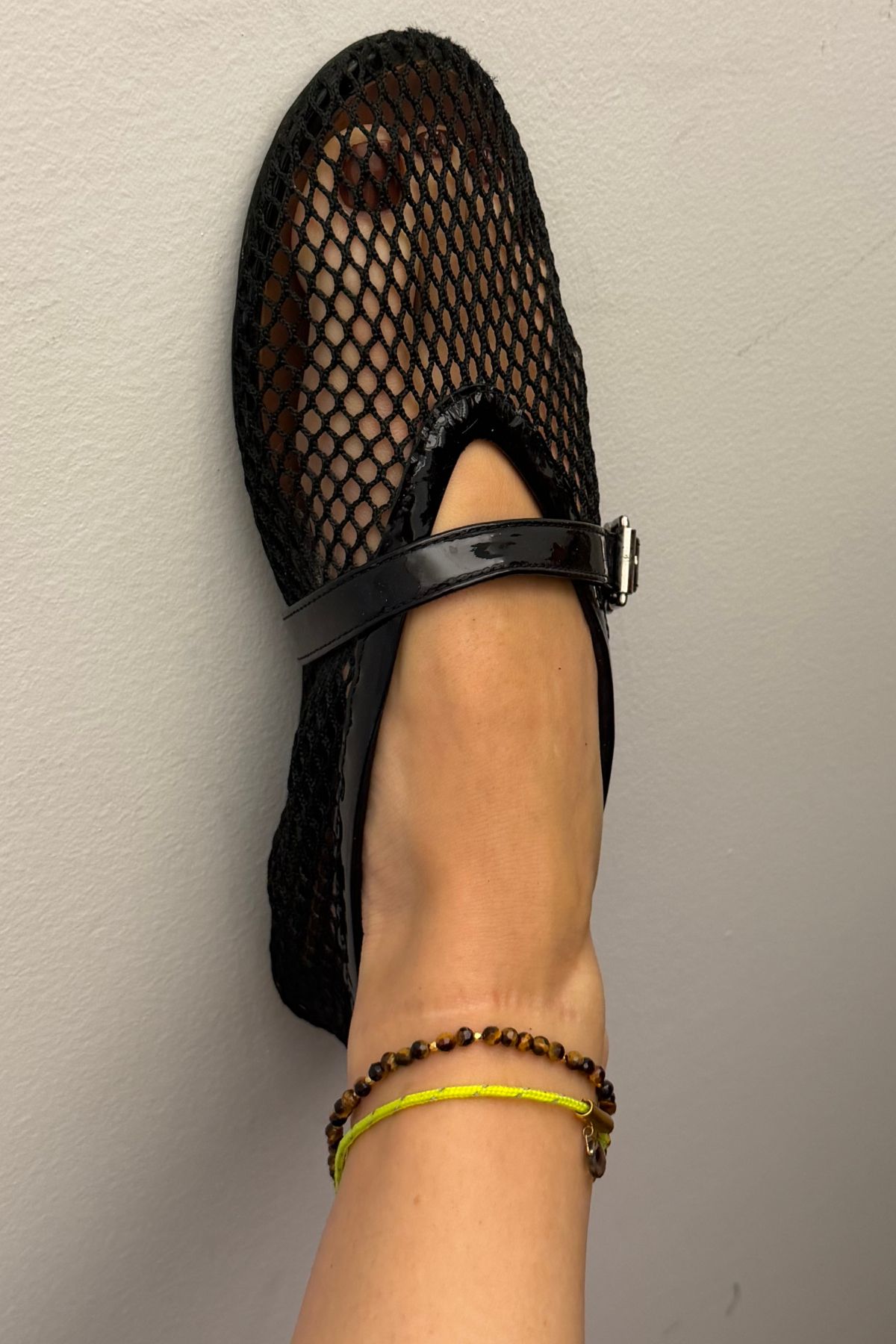 chocolate brown pedicure underneath netted black flats