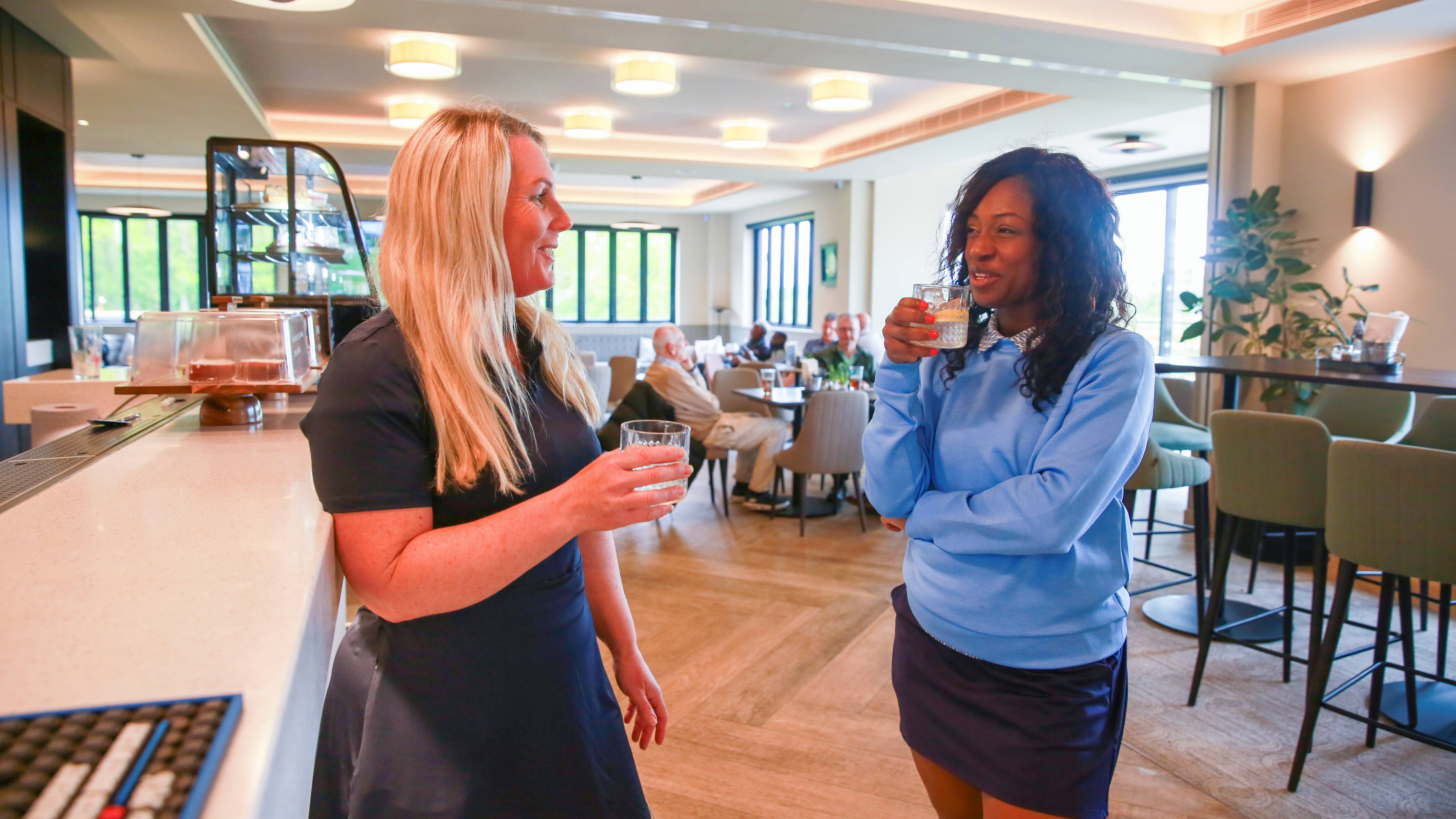 Two female golfers in the clubhouse bar
