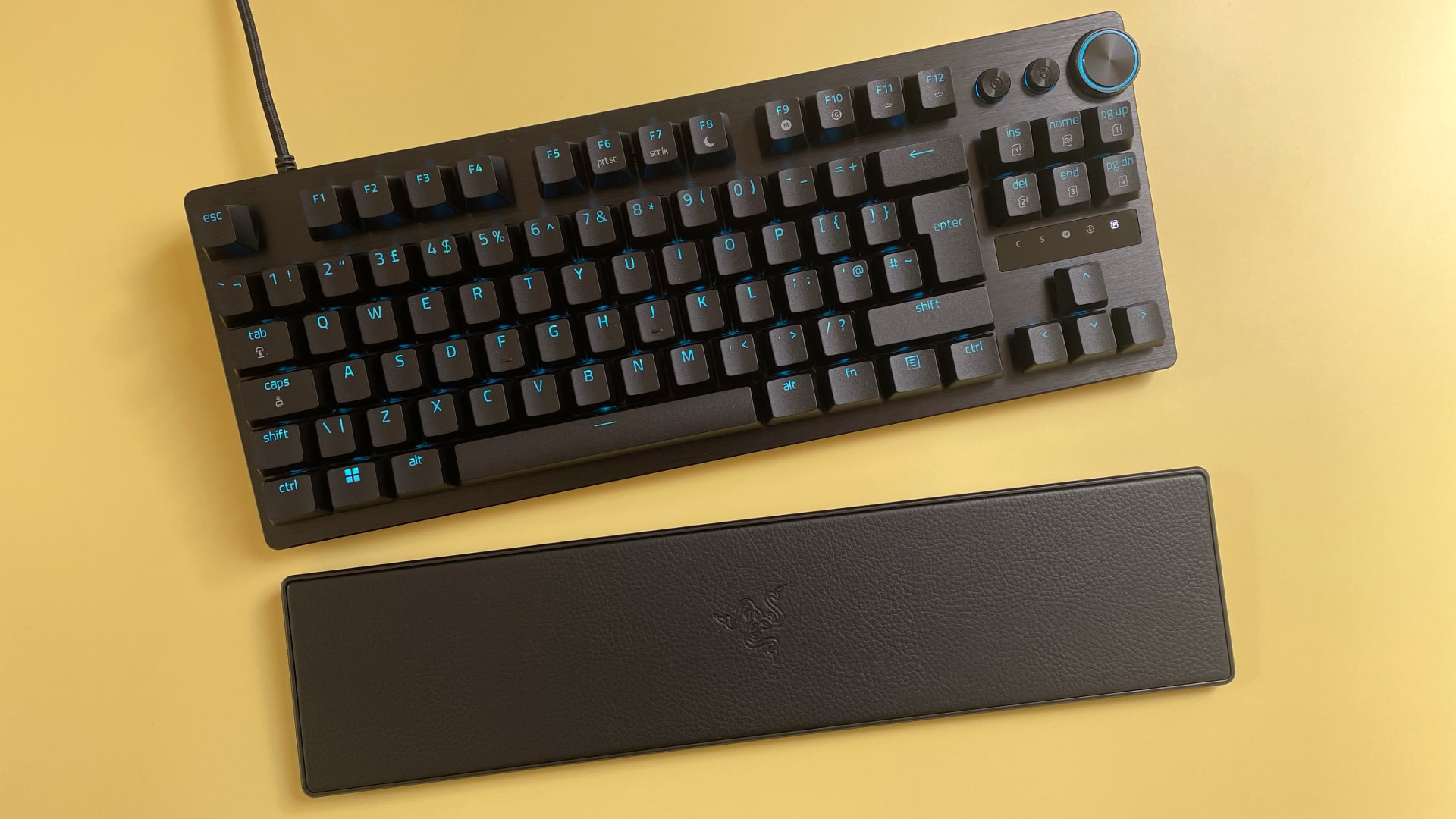 The Razer Huntsman V3 Pro Tenkeyless mechanical gaming keyboard against a yellow background.