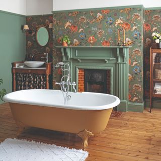 A bathroom with hardwood floors and a green-painted fireplace surrounded by green floral wallpaper