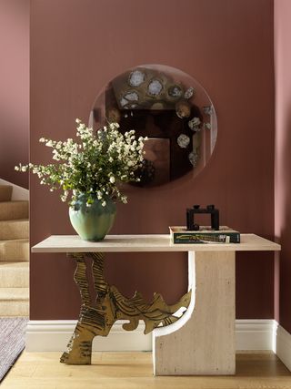 Dark pink walls, stone and gold tree table