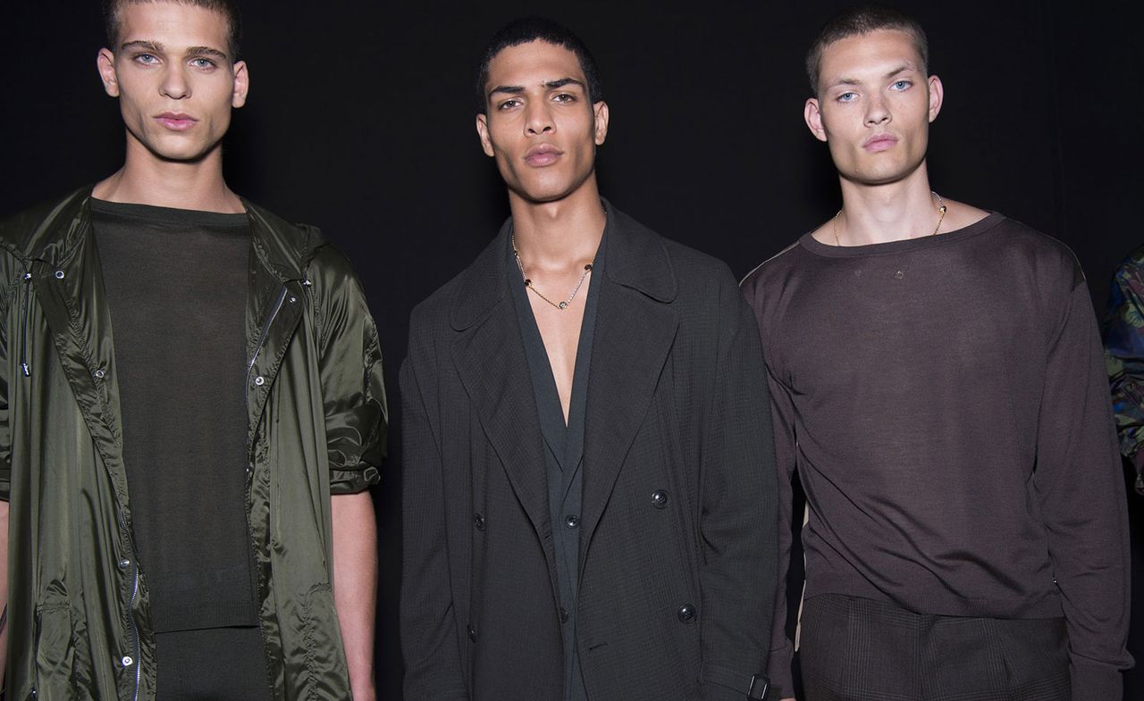 3 male models in dark clothing pose for the camera