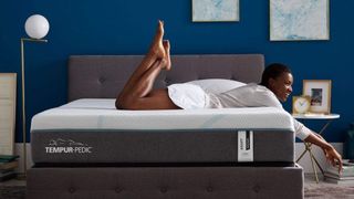 A woman lays on her stomach on top of the Tempur-Pedic Tempur-Adapt mattress