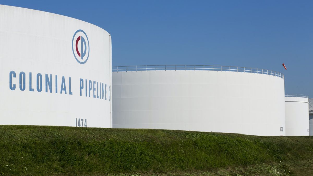 The Colonial Pipeline tanks situated on a green field with clear blue sky in background