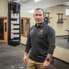Man stands next to hanging boxing bag