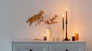 candles and dried flower vase on console table