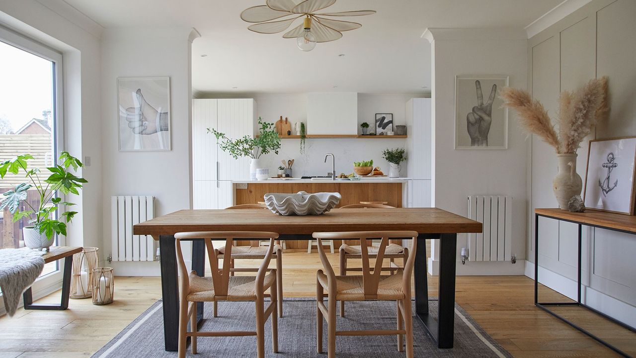 white kitchen diner with industrial table wishbone chairs grey rug pendant light kitchen island granite worktop