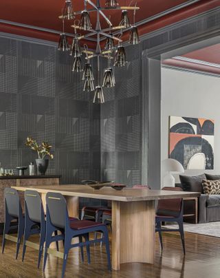 contemporary dining room with a wooden dining table, silver walls, and a red ceiling.